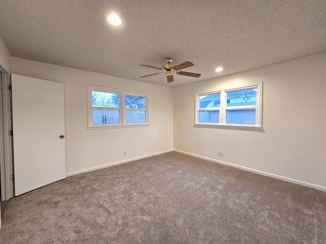 spare room featuring carpet flooring, ceiling fan, and a textured ceiling