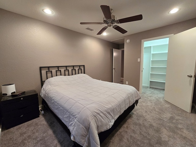 carpeted bedroom featuring a spacious closet and ceiling fan