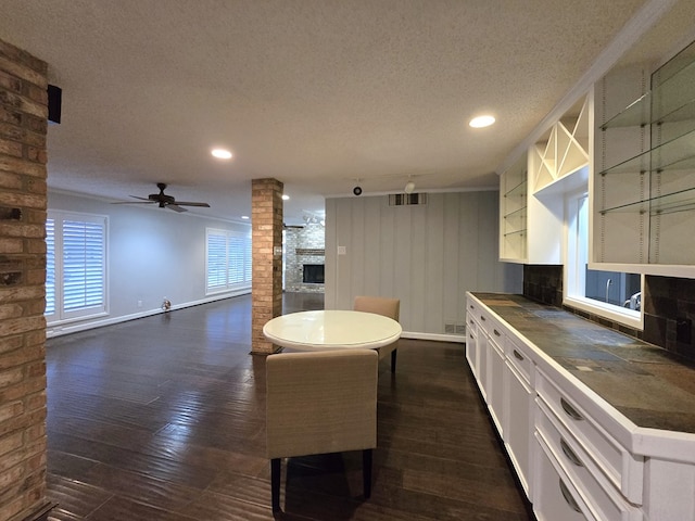 kitchen with white cabinets, ceiling fan, a textured ceiling, and dark wood-type flooring