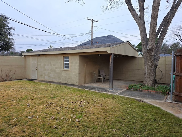 rear view of house featuring a patio area and a yard