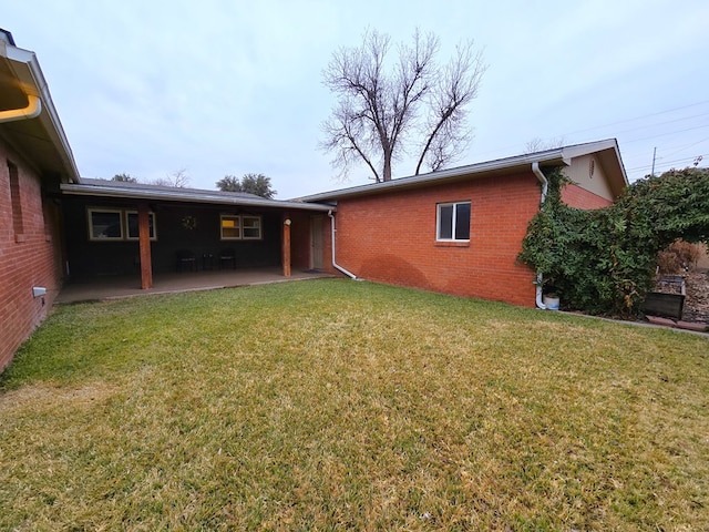 back of house featuring a patio area and a yard