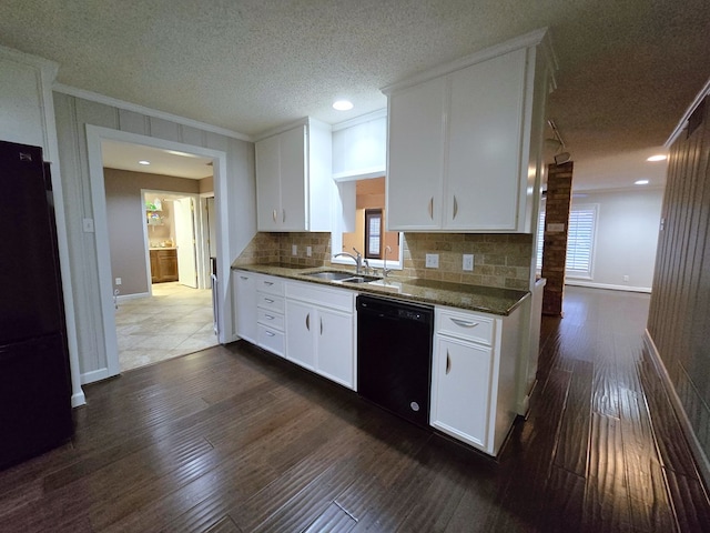 kitchen with dishwasher, dark stone counters, refrigerator, sink, and white cabinetry