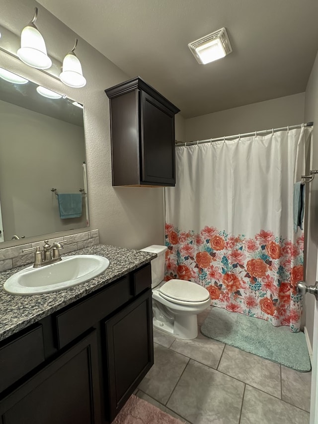 bathroom with tile patterned flooring, vanity, and toilet