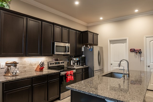 kitchen with stainless steel appliances, sink, and a center island with sink