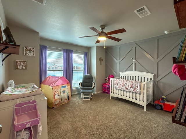 bedroom featuring ceiling fan, carpet, and a crib