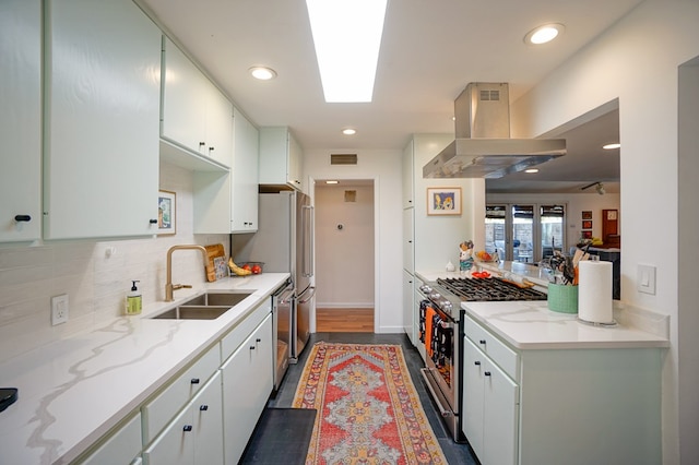 kitchen with sink, white cabinetry, stainless steel appliances, tasteful backsplash, and island range hood