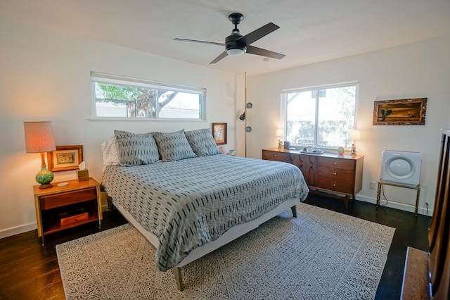 bedroom with dark wood-type flooring, ceiling fan, and multiple windows