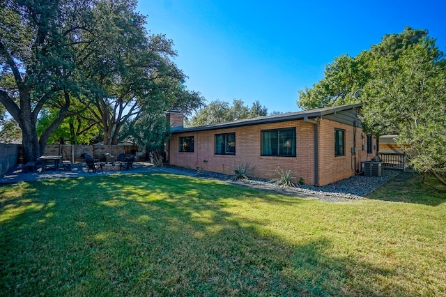 exterior space with central AC and a yard