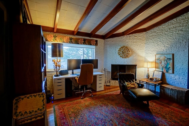 home office with hardwood / wood-style flooring and vaulted ceiling with beams