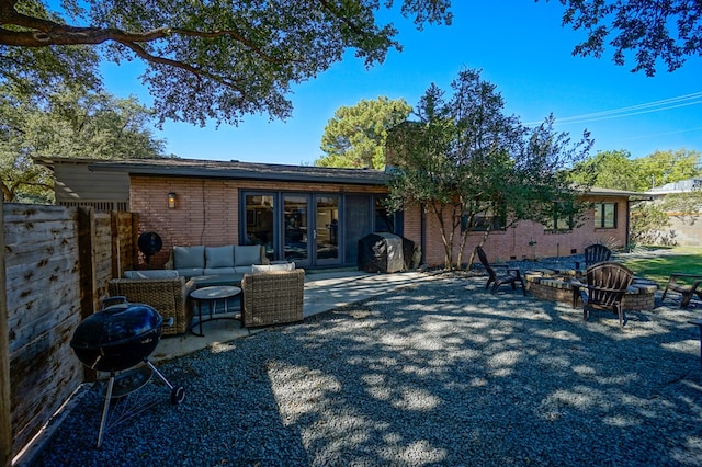 back of house featuring a patio and an outdoor living space with a fire pit