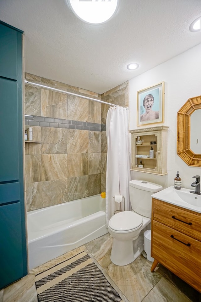 full bathroom with shower / tub combo with curtain, vanity, toilet, and a textured ceiling