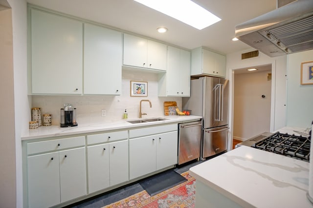 kitchen with stainless steel appliances, island range hood, sink, and white cabinets