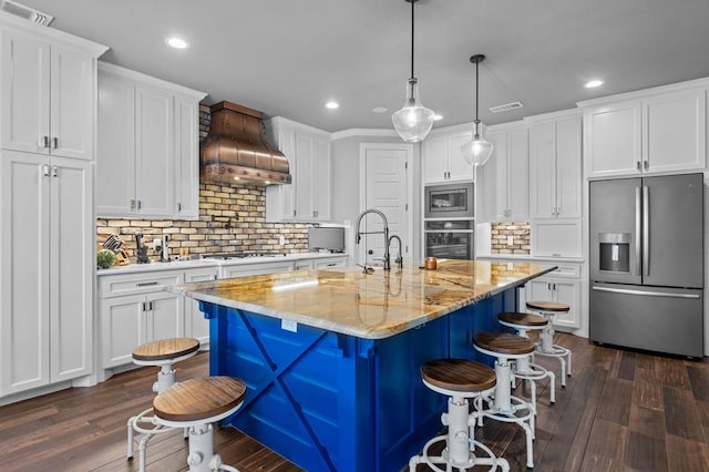 kitchen featuring white cabinets, dark hardwood / wood-style flooring, stainless steel appliances, and premium range hood