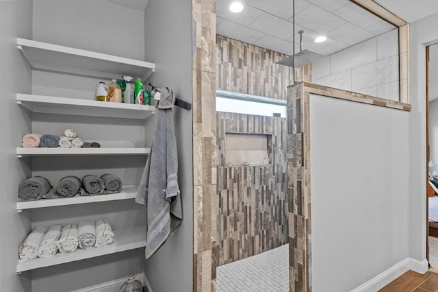 bathroom with wood-type flooring and tiled shower