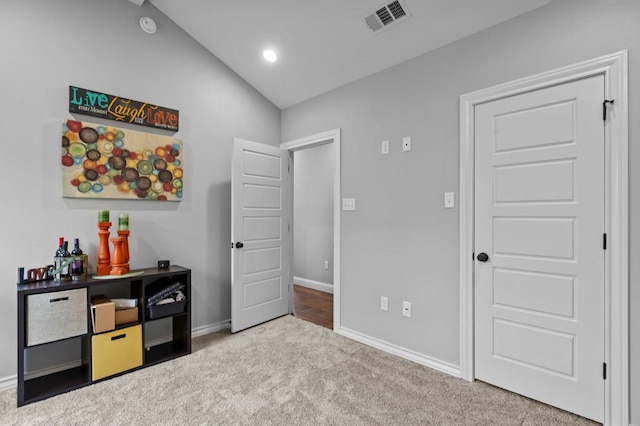 carpeted bedroom with lofted ceiling