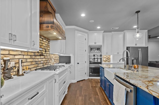 kitchen with white cabinets, blue cabinets, dark hardwood / wood-style floors, appliances with stainless steel finishes, and decorative light fixtures