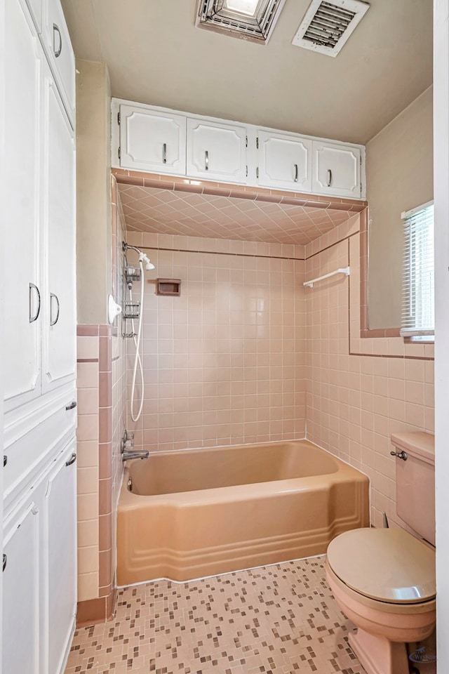 1510 W School St, Stanton, TX 79782 - bathroom featuring tile walls, toilet, shower / washtub combination, and tile patterned floors