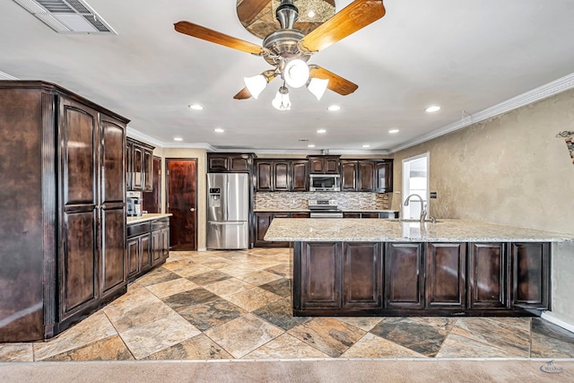 1510 W School St, Stanton, TX 79782 - kitchen with appliances with stainless steel finishes, a sink, crown molding, recessed lighting, and light stone finish flooring