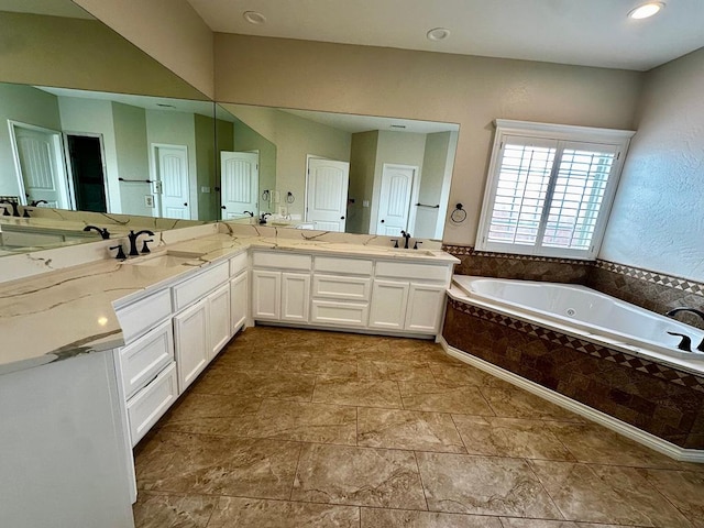 full bathroom with a sink, double vanity, and a garden tub