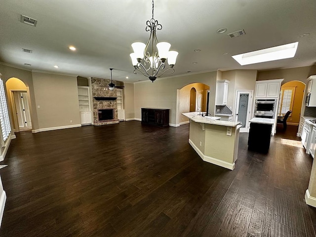 kitchen with light countertops, open floor plan, visible vents, and a large fireplace