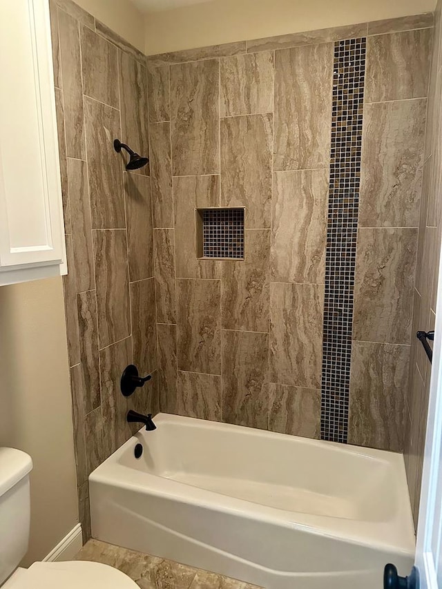 bathroom with toilet, shower / bath combination, and baseboards