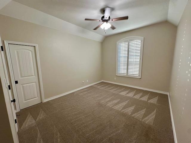 carpeted spare room with ceiling fan, lofted ceiling, and baseboards