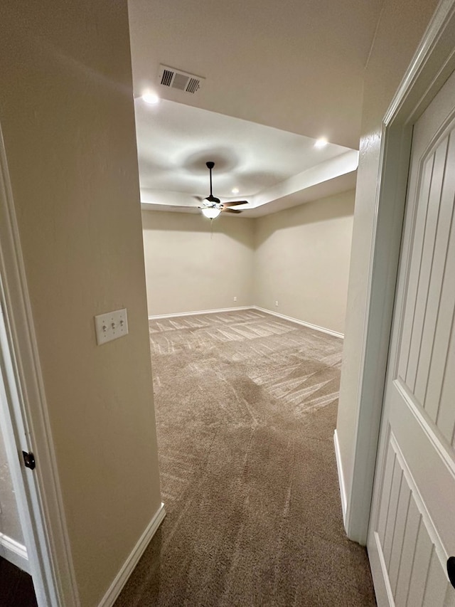 carpeted empty room with recessed lighting, baseboards, visible vents, ceiling fan, and a raised ceiling