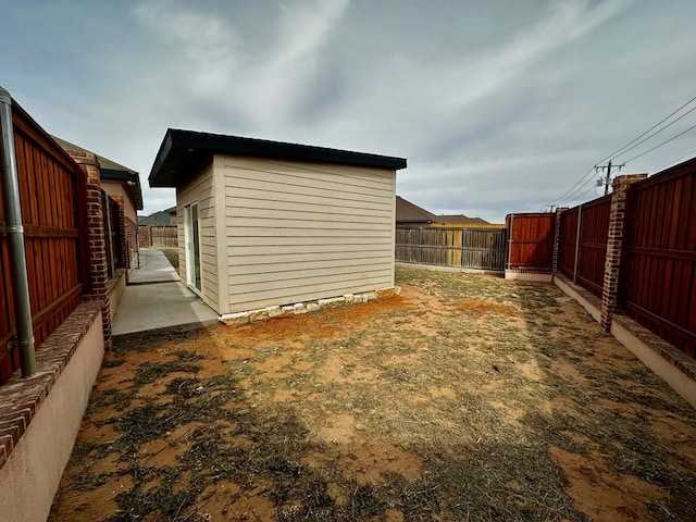 view of yard with a fenced backyard and an outbuilding