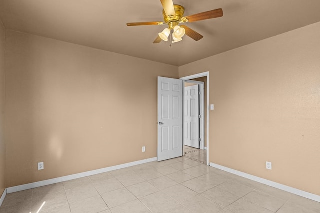 empty room featuring baseboards, ceiling fan, and light tile patterned floors