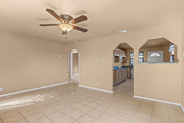 610 S Clay St, Midland, TX 79701 - spare room with arched walkways, light tile patterned floors, ceiling fan, and baseboards