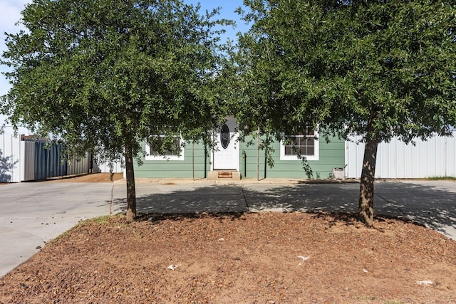 610 S Clay St, Midland, TX 79701 - view of property hidden behind natural elements with fence, concrete driveway, and entry steps