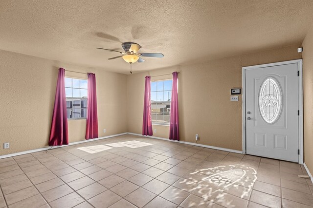 610 S Clay St, Midland, TX 79701 - entrance foyer with ceiling fan, a textured wall, a textured ceiling, light tile patterned flooring, and baseboards