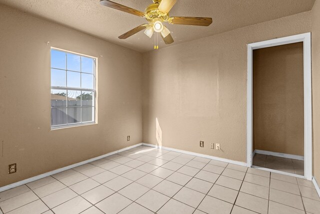610 S Clay St, Midland, TX 79701 - spare room with light tile patterned floors, a textured ceiling, a ceiling fan, and baseboards