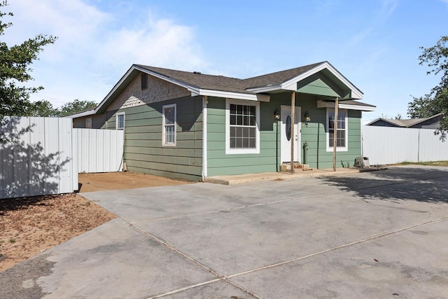view of front facade with fence and concrete driveway