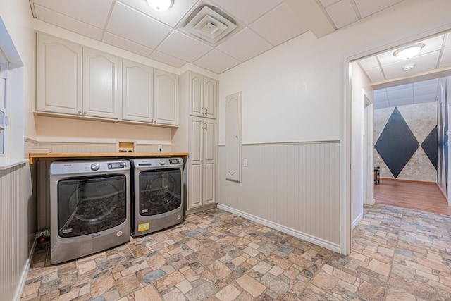 1207 Kansas, Midland, TX 79705 - washroom featuring independent washer and dryer, cabinet space, a wainscoted wall, and light stone finish floors