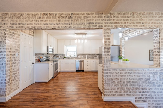 1207 Kansas, Midland, TX 79705 - kitchen featuring appliances with stainless steel finishes, dark wood-style floors, white cabinetry, light countertops, and tasteful backsplash