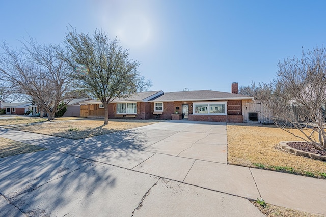 1207 Kansas, Midland, TX 79705 - ranch-style home with brick siding, a chimney, and concrete driveway