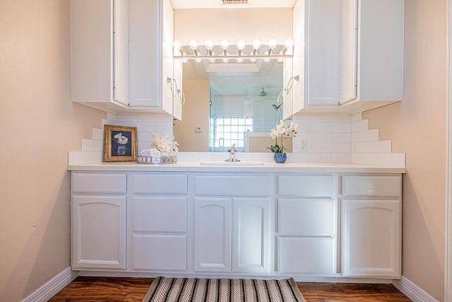 1207 Kansas, Midland, TX 79705 - bathroom with a shower, wood finished floors, vanity, and backsplash