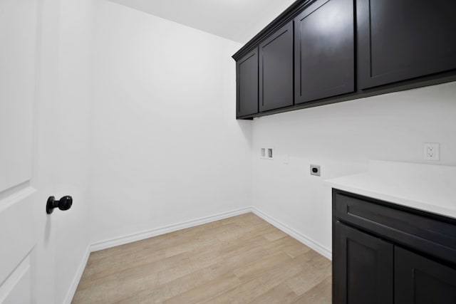 washroom with cabinets, hookup for a washing machine, light hardwood / wood-style floors, and electric dryer hookup