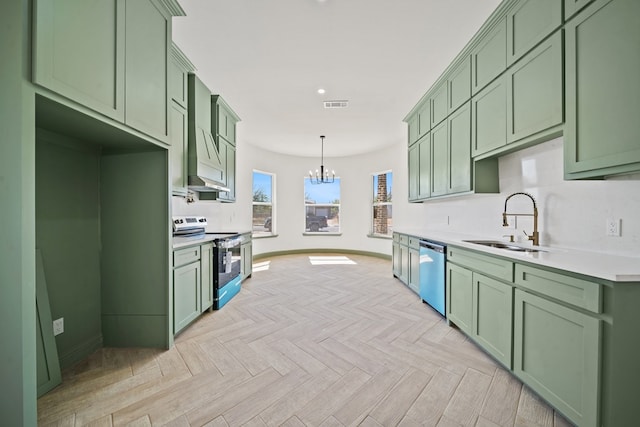 kitchen with stainless steel appliances, light parquet floors, sink, decorative light fixtures, and green cabinetry