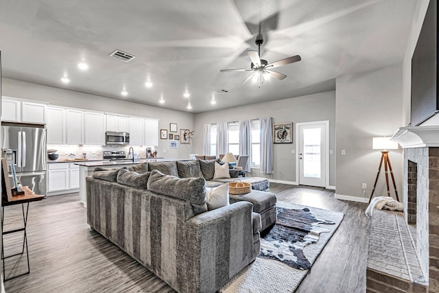 2408 Partridge St, Midland, TX 79705 - living room with wood finished floors, recessed lighting, a ceiling fan, and a brick fireplace