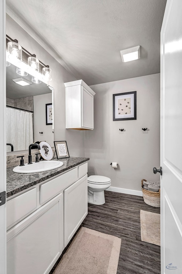 2408 Partridge St, Midland, TX 79705 - bathroom featuring vanity, wood finished floors, and a textured ceiling