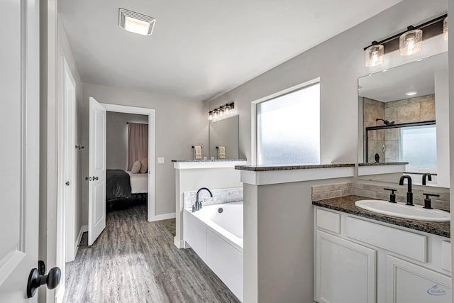 2408 Partridge St, Midland, TX 79705 - full bath featuring a bath, wood finished floors, vanity, ensuite bathroom, and tiled shower