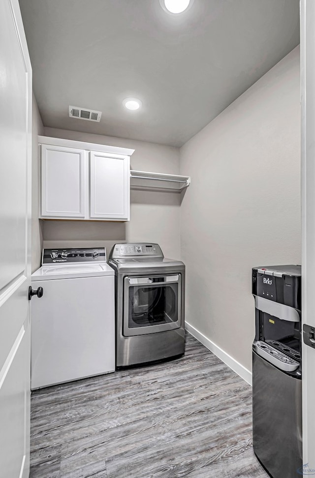 2408 Partridge St, Midland, TX 79705 - laundry room with washing machine and clothes dryer, cabinet space, light wood-type flooring, and recessed lighting