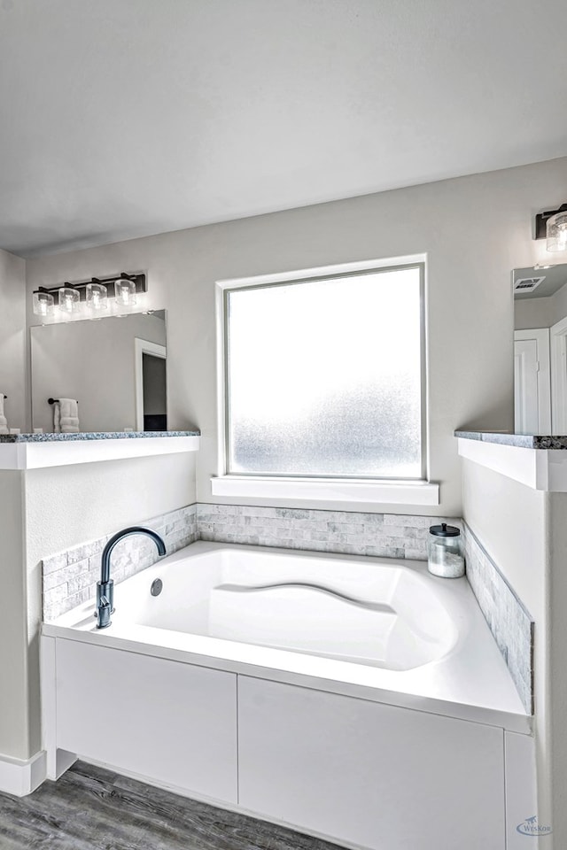 2408 Partridge St, Midland, TX 79705 - full bath featuring healthy amount of natural light, a garden tub, and wood finished floors