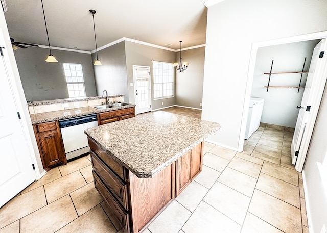 kitchen with a sink, crown molding, dishwasher, brown cabinets, and separate washer and dryer