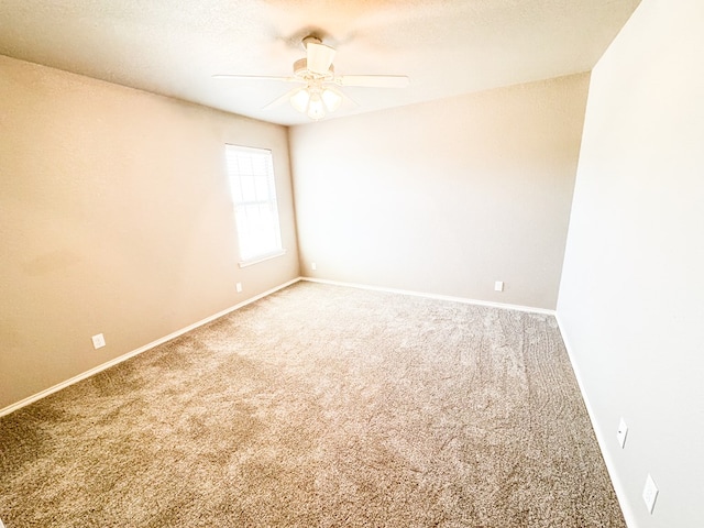 spare room with baseboards, carpet, ceiling fan, and a textured ceiling