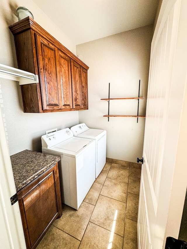 clothes washing area with washer and dryer, light tile patterned floors, and cabinet space