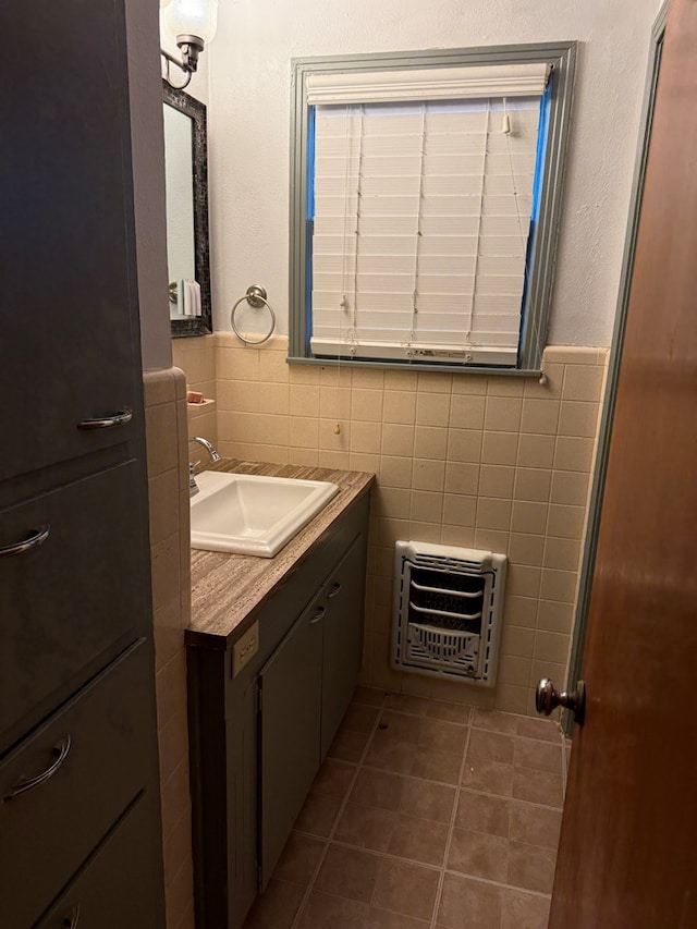 bathroom featuring heating unit, vanity, tile walls, and tile patterned floors