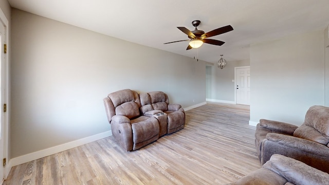 living area with baseboards, ceiling fan, and light wood-style floors